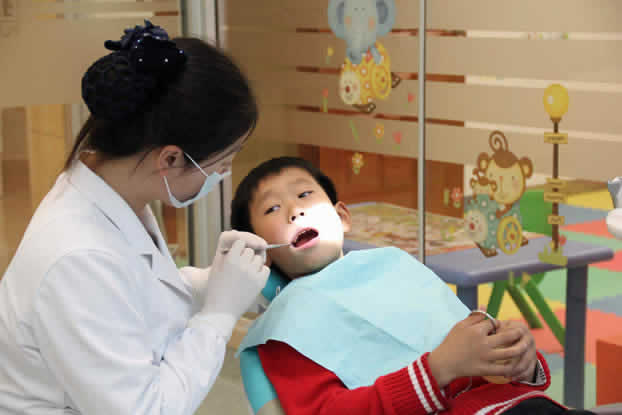 杭州牙科医院医生正在给孩子检查口腔